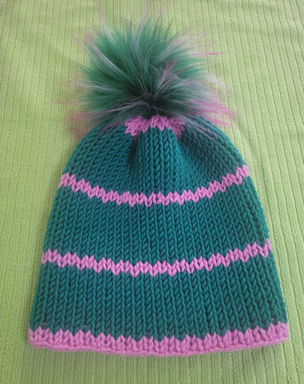 Beanie - green with pink stripe. Green pom pom with a hint of pink